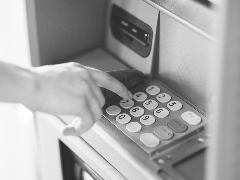 Close-Up of Hand Typing Pin on ATM Keyboard