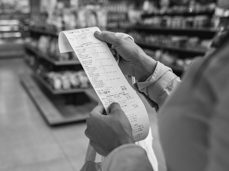 Close-Up of Person Holding Receipt in Grocery Store