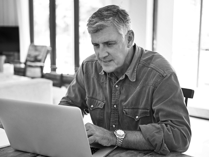 Farmer Sitting at Desk on Laptop